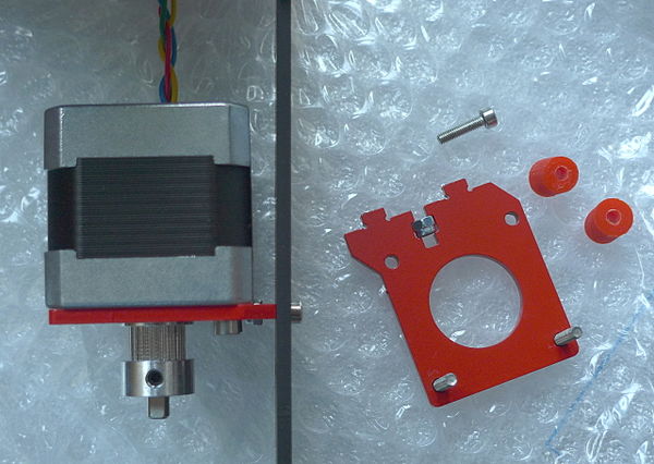 The Y-axis stepper and GT2 pulley installed. The remaining parts for this step are shown on the right
